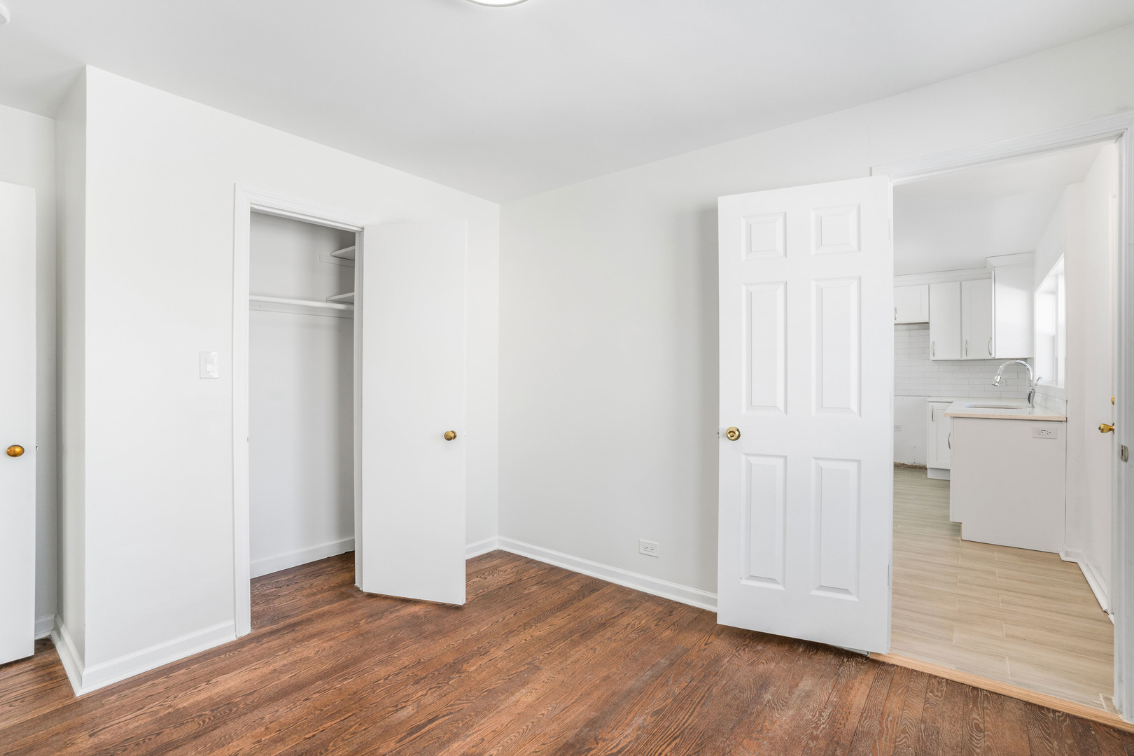 8110 46th Street Lyons, IL 60534 - Photo 11 of 26 a view of an empty room with wooden floor and a kitchen