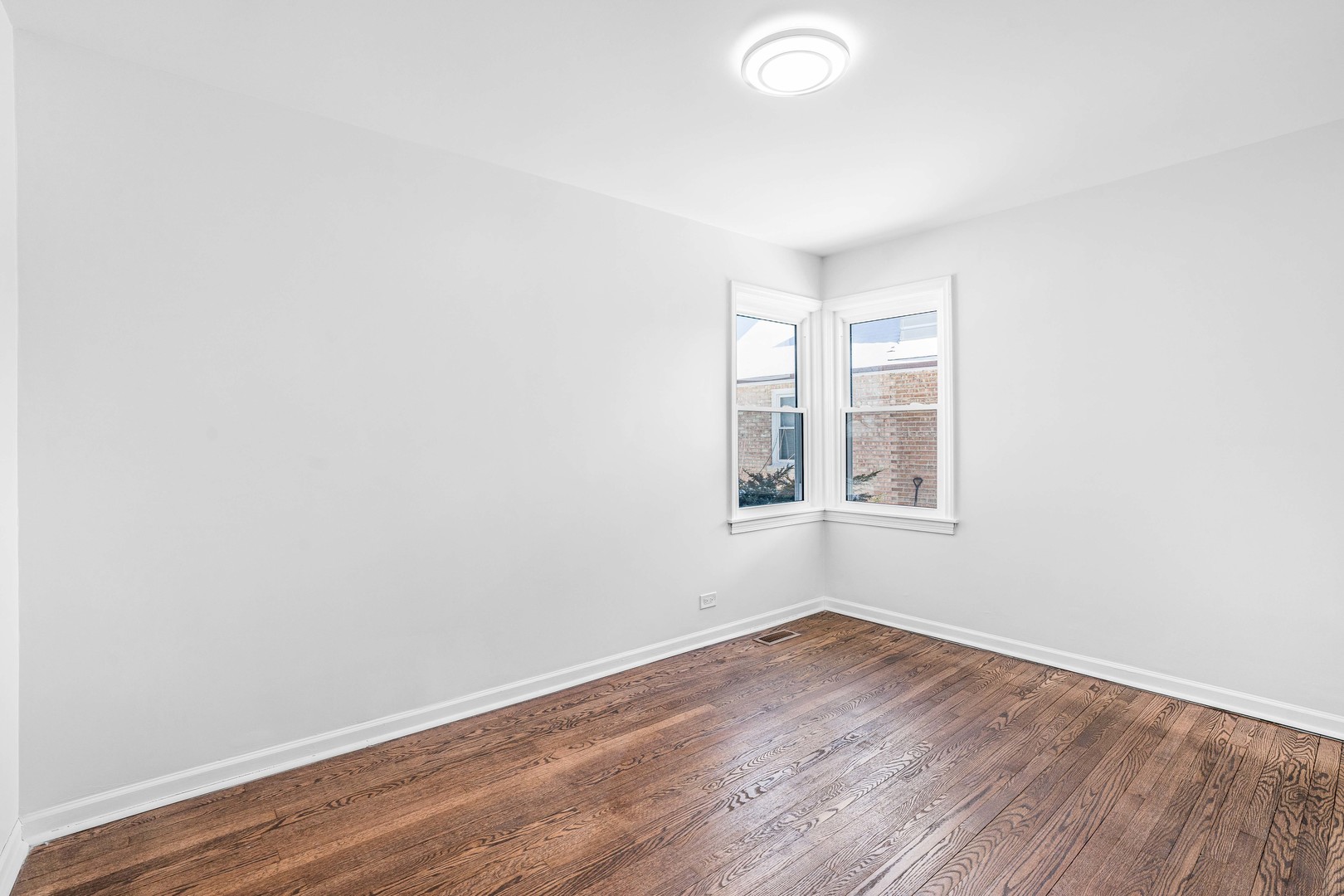8110 46th Street Lyons, IL 60534 - Photo 13 of 26 an empty room with wooden floor and windows