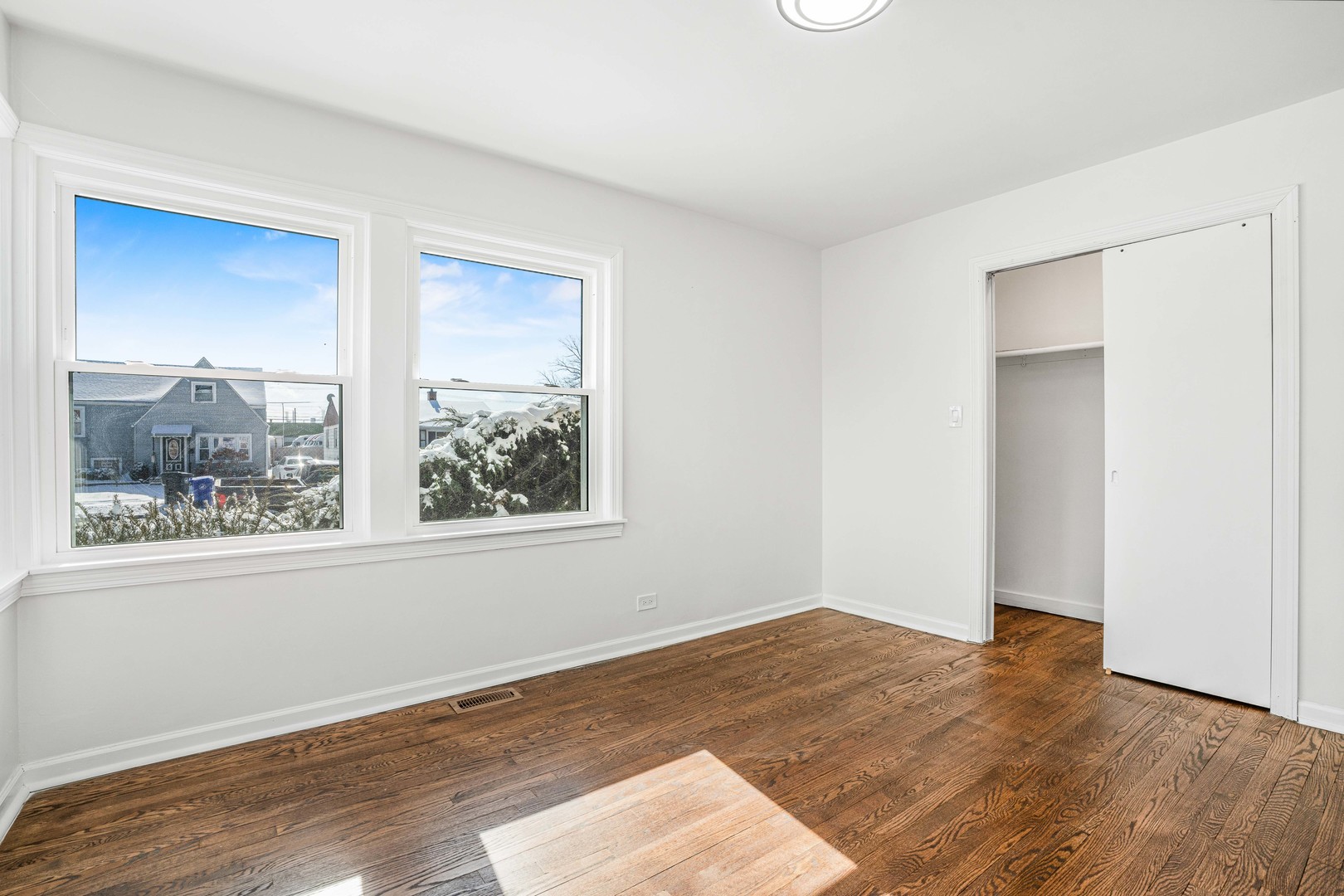 8110 46th Street Lyons, IL 60534 - Photo 16 of 26 a view of empty room with wooden floor and fan