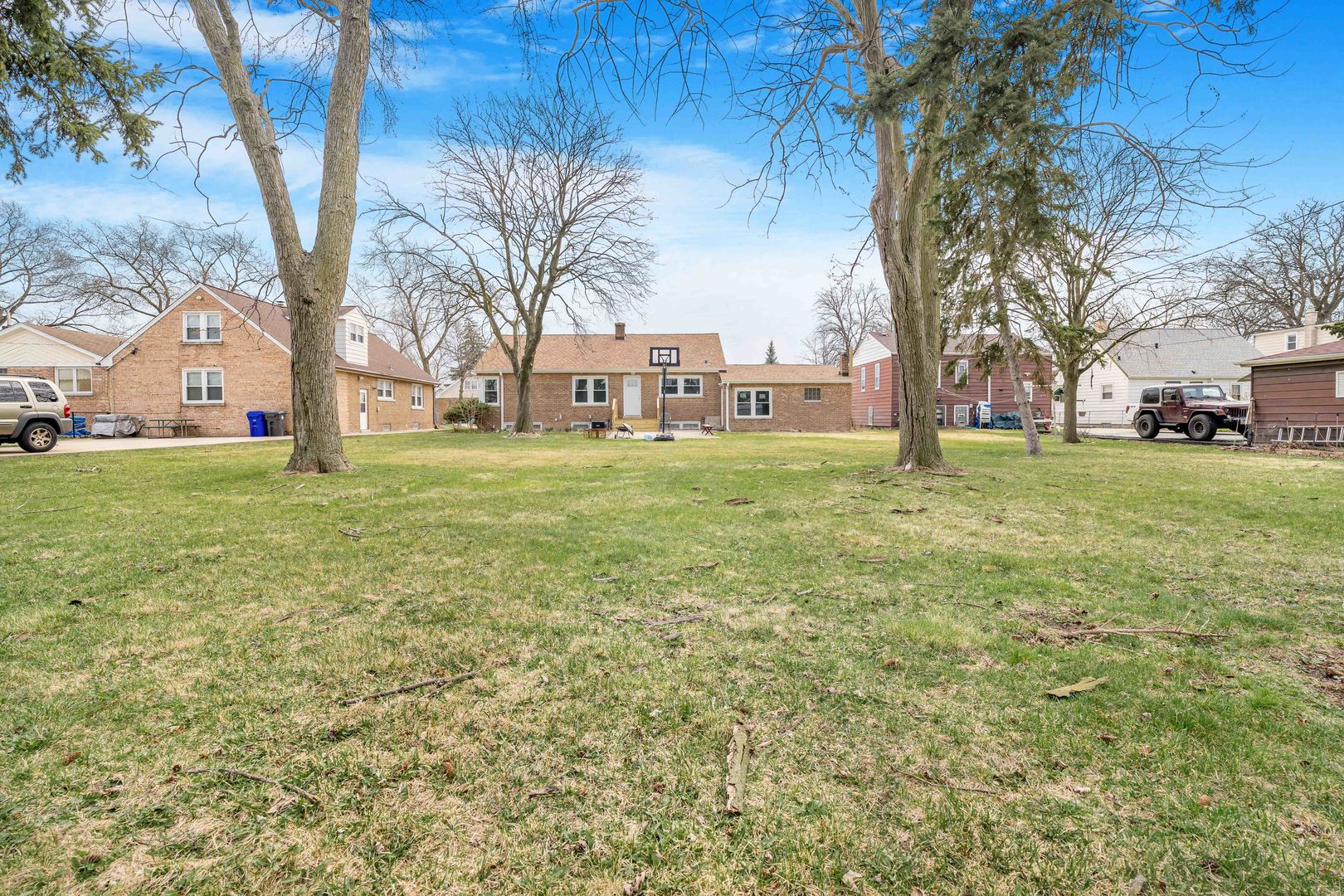 8110 46th Street Lyons, IL 60534 - Photo 22 of 26 a tall tree is sitting in the grass with large trees