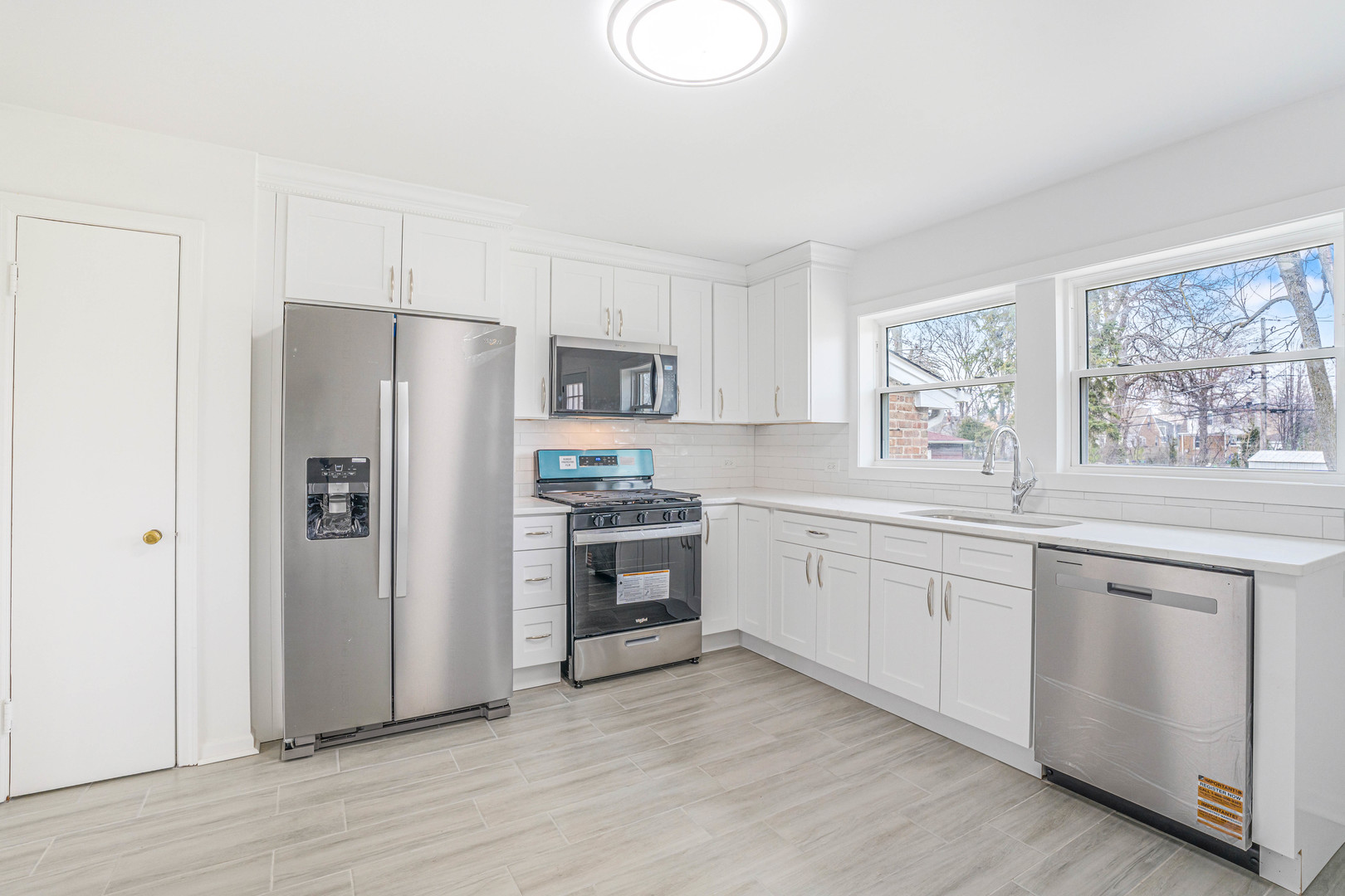 8110 46th Street Lyons, IL 60534 - Photo 5 of 26 a kitchen with granite countertop a refrigerator stove and sink