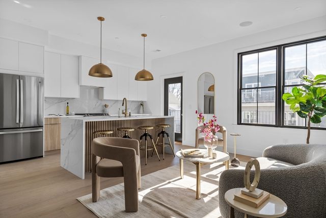 a kitchen with stainless steel appliances granite countertop a stove a sink dishwasher a dining table and chairs with wooden floor