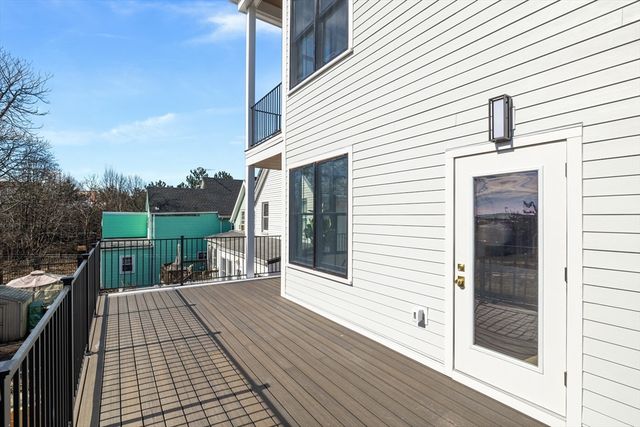 a view of a patio with dining table and chairs with wooden floor and fence