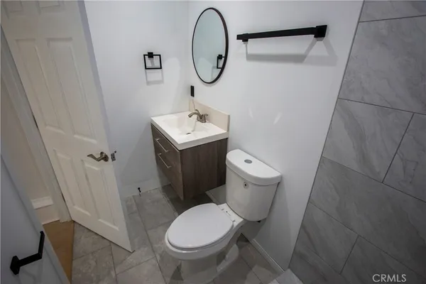a bathroom with a toilet sink vanity and mirror