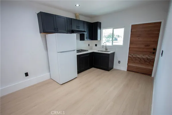 a kitchen with a refrigerator sink and cabinets