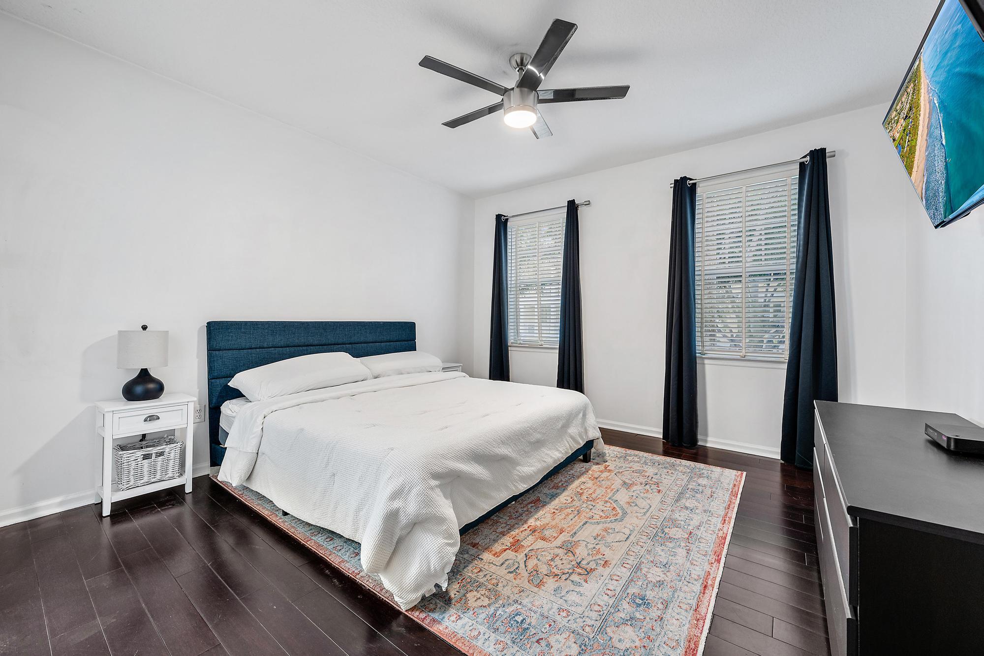 225 Murcia Drive, Unit 201 Jupiter, FL 33458 - Photo 21 of 42 a bedroom with a large bed and a chandelier