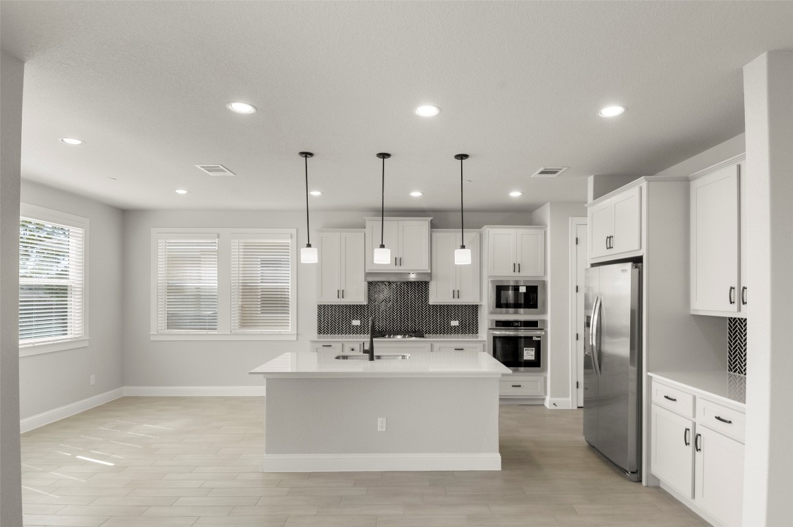 2605 Sam Bass Road, Unit 87 Round Rock, TX 78681 - Photo 14 of 31 a large white kitchen with stainless steel appliances