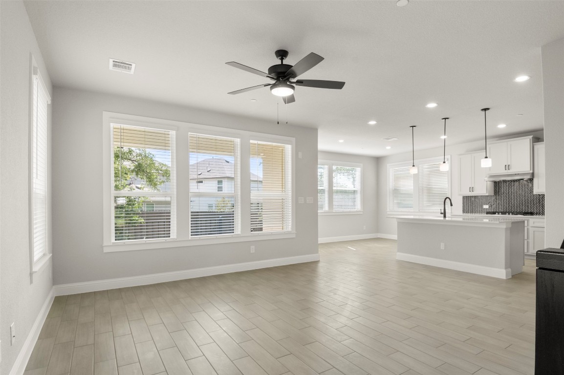 2605 Sam Bass Road, Unit 87 Round Rock, TX 78681 - Photo 6 of 31 a view of an empty room with window cabinet a kitchen and chandelier fan