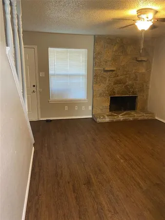 a view of a livingroom with wooden floor and a fireplace