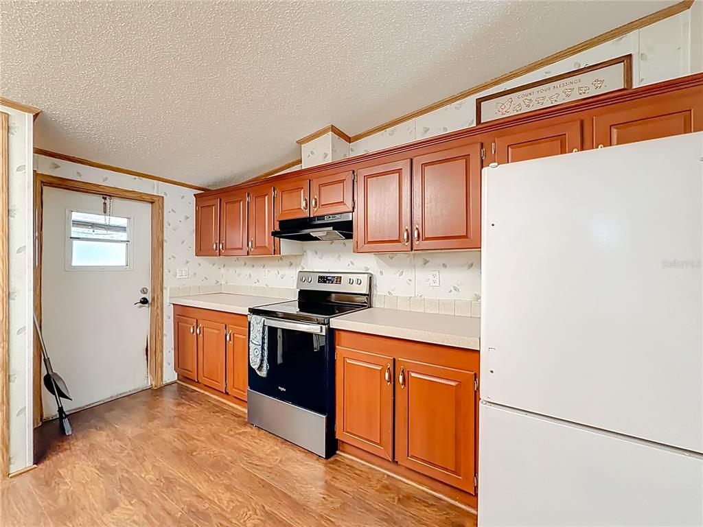 9575 Southwest 155th Street Dunnellon, FL 34432 - Photo 13 of 50 a kitchen with stainless steel appliances granite countertop a refrigerator sink and cabinets