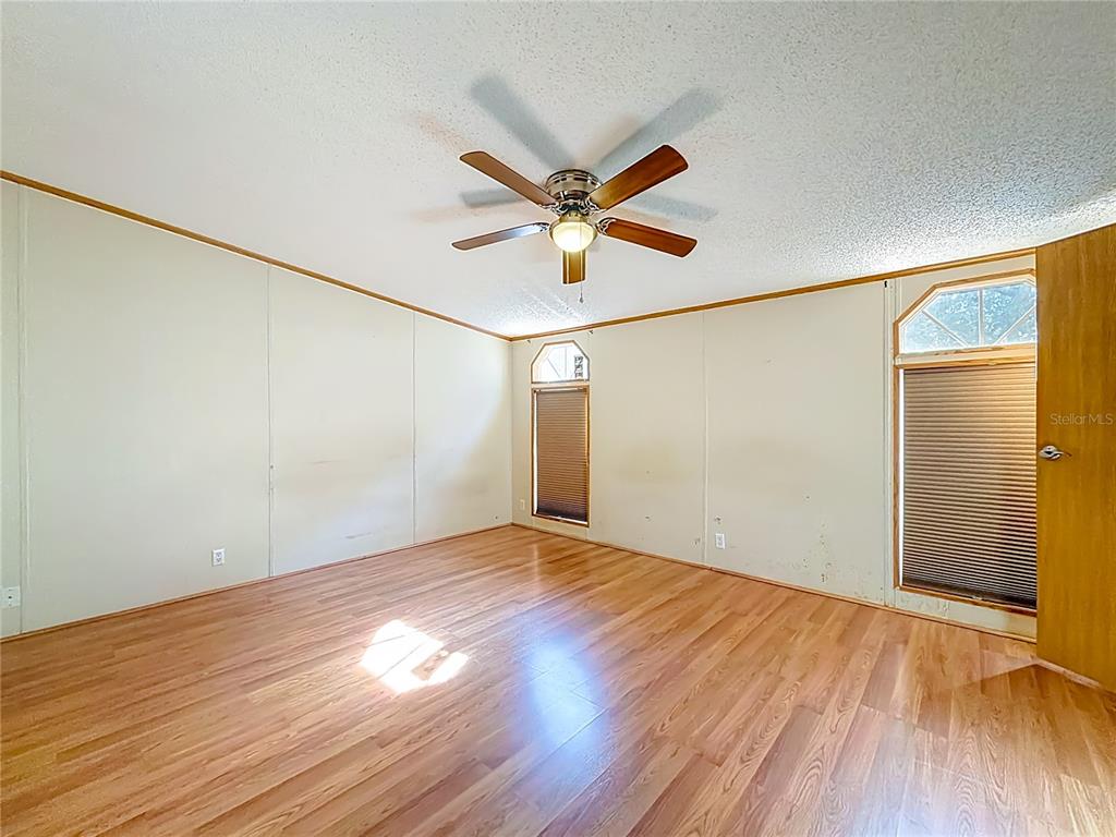9575 Southwest 155th Street Dunnellon, FL 34432 - Photo 21 of 50 a view of a big room with wooden floor and a ceiling fan