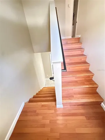 a view of a hallway with wooden floor and staircase