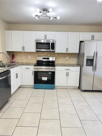 a kitchen with cabinets and steel stainless steel appliances