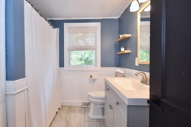a bathroom with a sink a toilet and a mirror