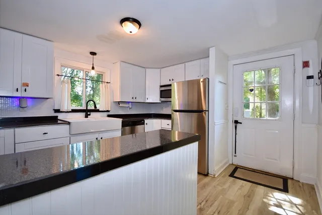 a kitchen with granite countertop a refrigerator and a stove top oven