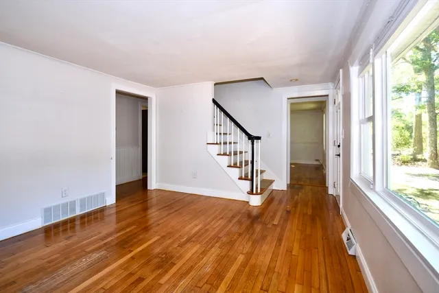 a view of a hallway with wooden floor and staircase