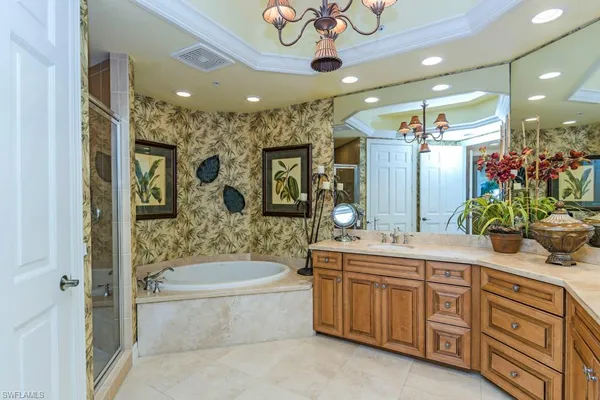 a spacious bathroom with a granite countertop sink mirror and bathtub
