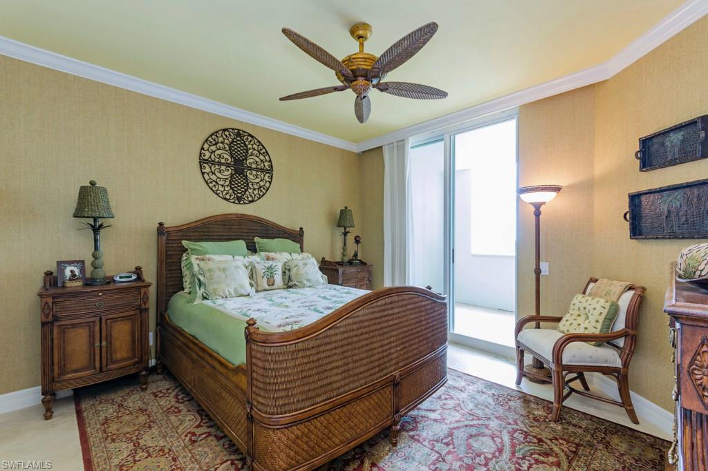 295 Grande Way, Unit 503 Naples, FL 34110 - Photo 9 of 24 a bedroom with a bed and a chandelier