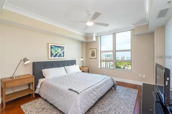 a bedroom with a large bed a chandelier and a window