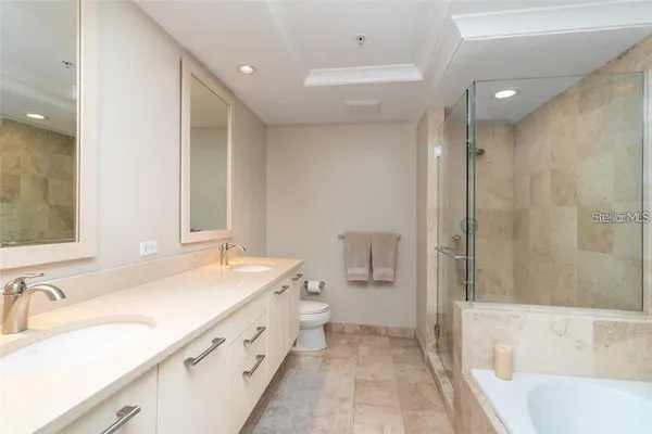 a spacious bathroom with a tub sink and mirror