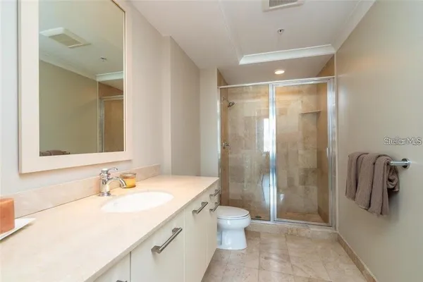 a bathroom with a granite countertop sink a toilet and shower