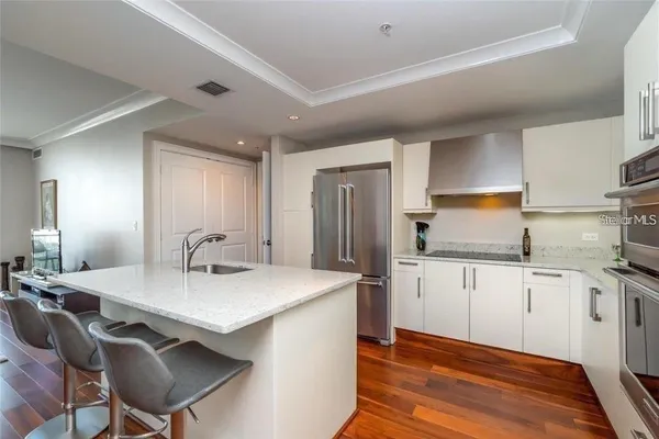 a kitchen with granite countertop a sink stove and refrigerator