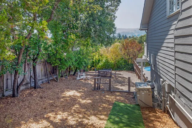 a view of a backyard with plants and a barbeque