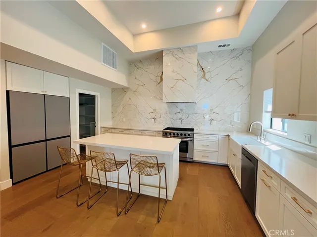 a kitchen with stainless steel appliances a refrigerator and a stove top oven