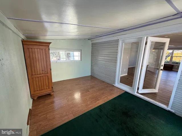 an entryway with wooden floor and cabinet