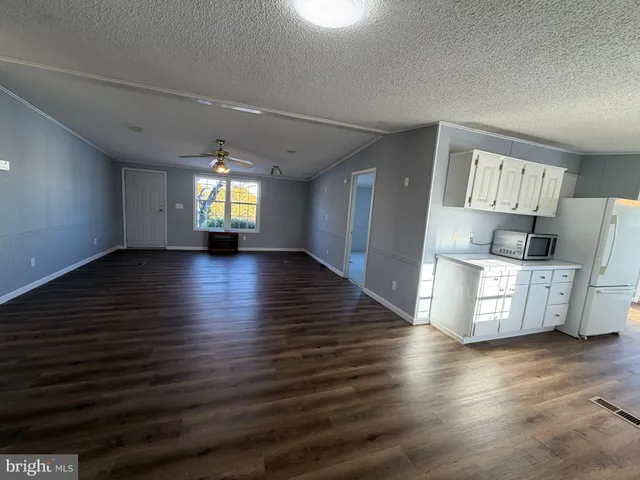 a view of a kitchen with furniture and wooden floor