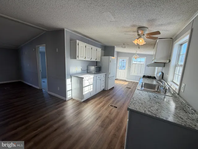 a kitchen with sink cabinets and wooden floor