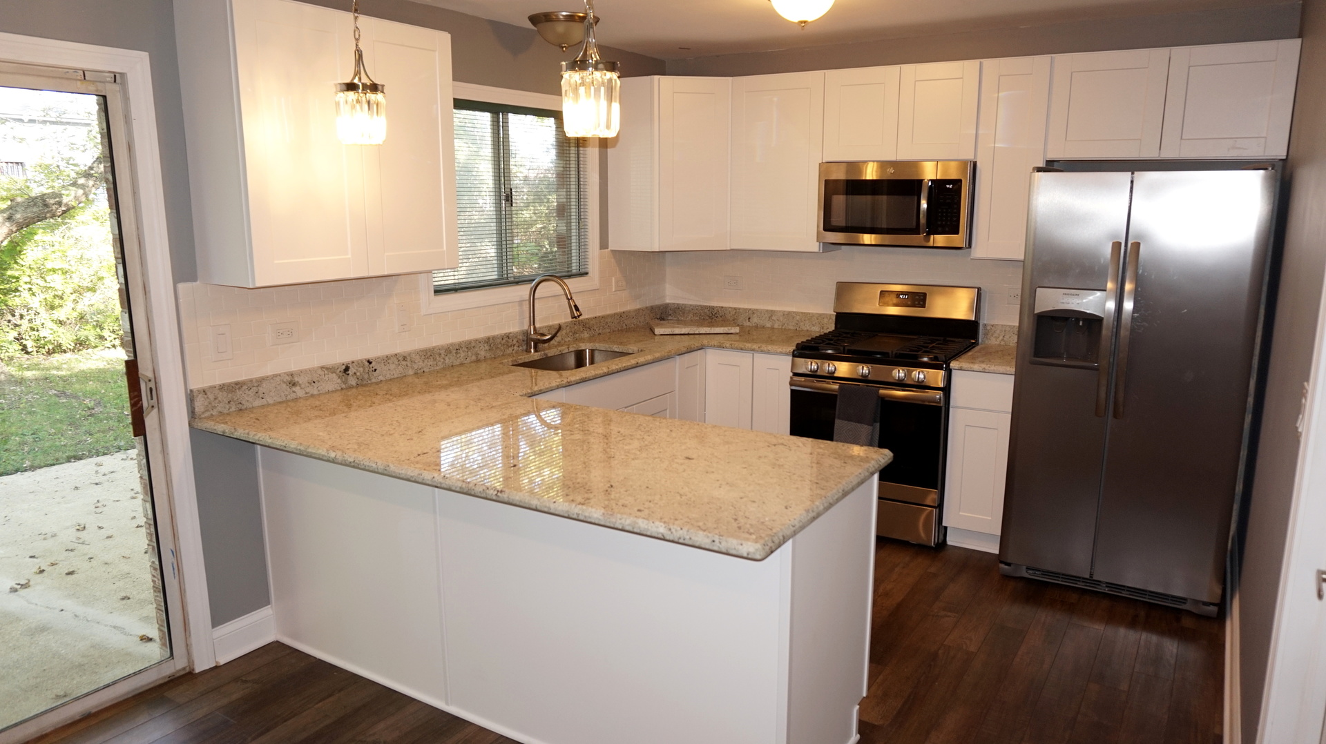 5740 Timberlane Road Matteson, IL 60443 - Photo 7 of 17 a kitchen with kitchen island granite countertop stainless steel appliances a sink stove refrigerator and a window