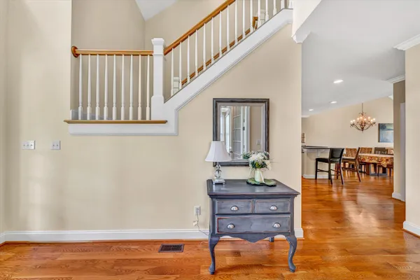 a kitchen with stainless steel appliances granite countertop a table chairs stove a sink dishwasher and cabinets with wooden floor