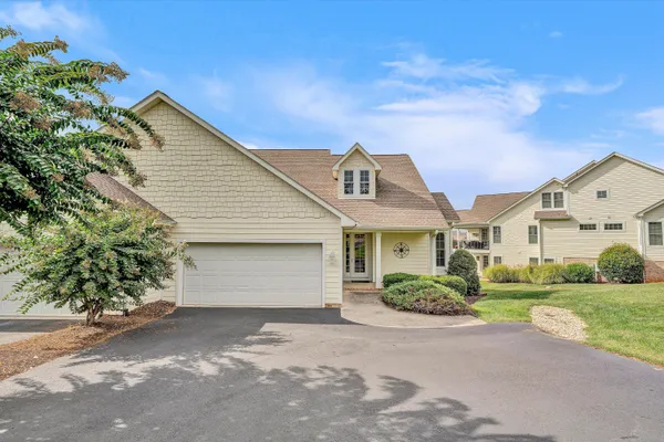 an aerial view of a house with swimming pool and large trees