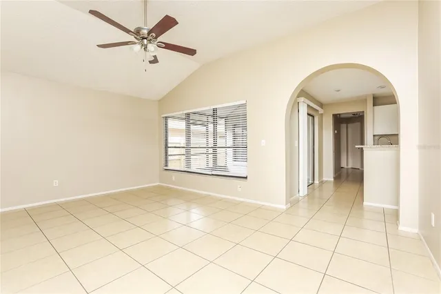 a view of a livingroom with a chandelier fan and windows