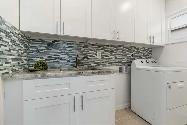 a kitchen with granite countertop white cabinets and white appliances