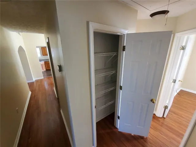 a view of walk in closet with wooden floor and stairs