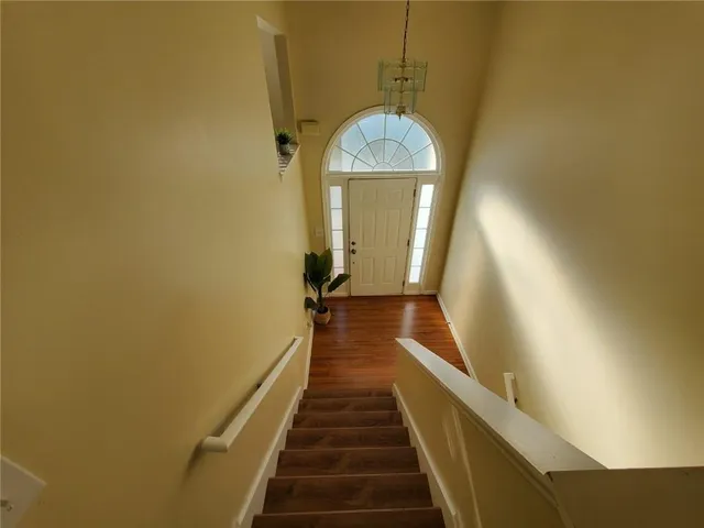 a view of a hallway with wooden floor and staircase