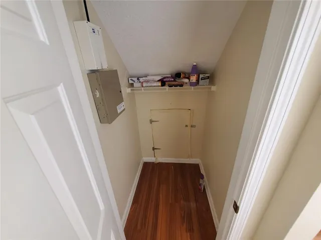 a view of a room with wooden floor and white walls