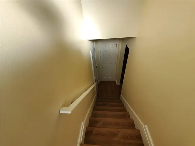a view of a hallway with wooden floor and stairs