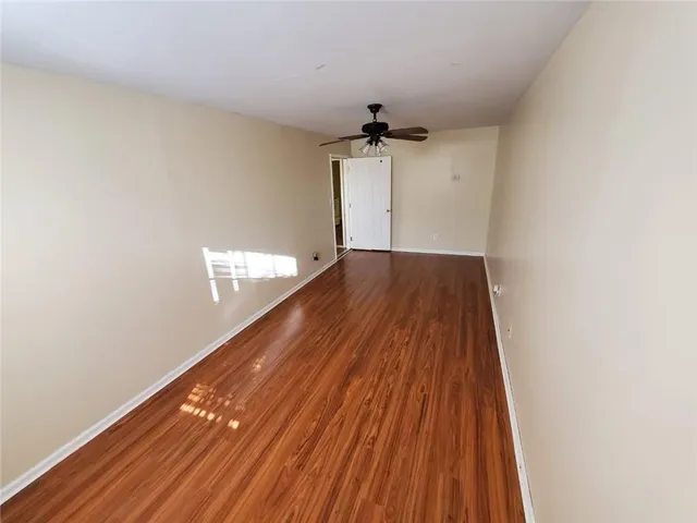 a view of empty room with wooden floor