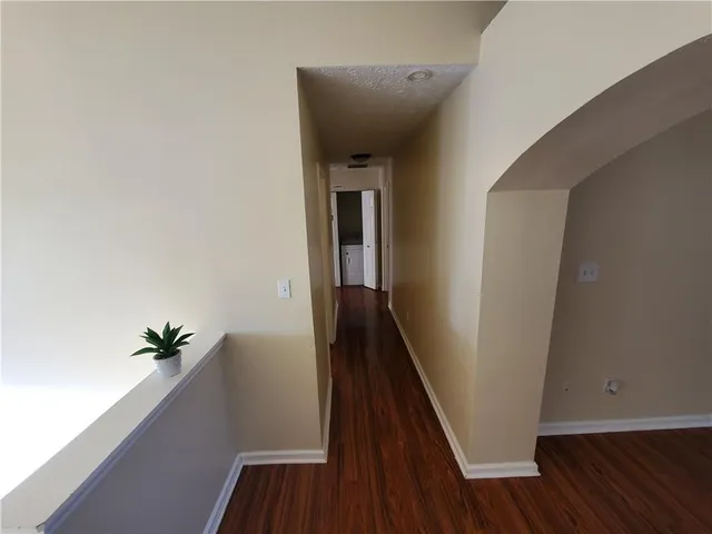 a view of a hallway with wooden floor and stairs