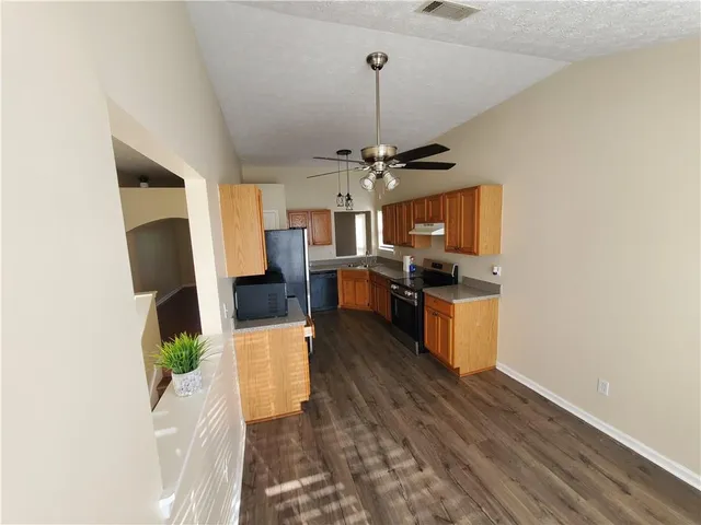 a kitchen with stainless steel appliances kitchen island granite countertop a refrigerator and a stove