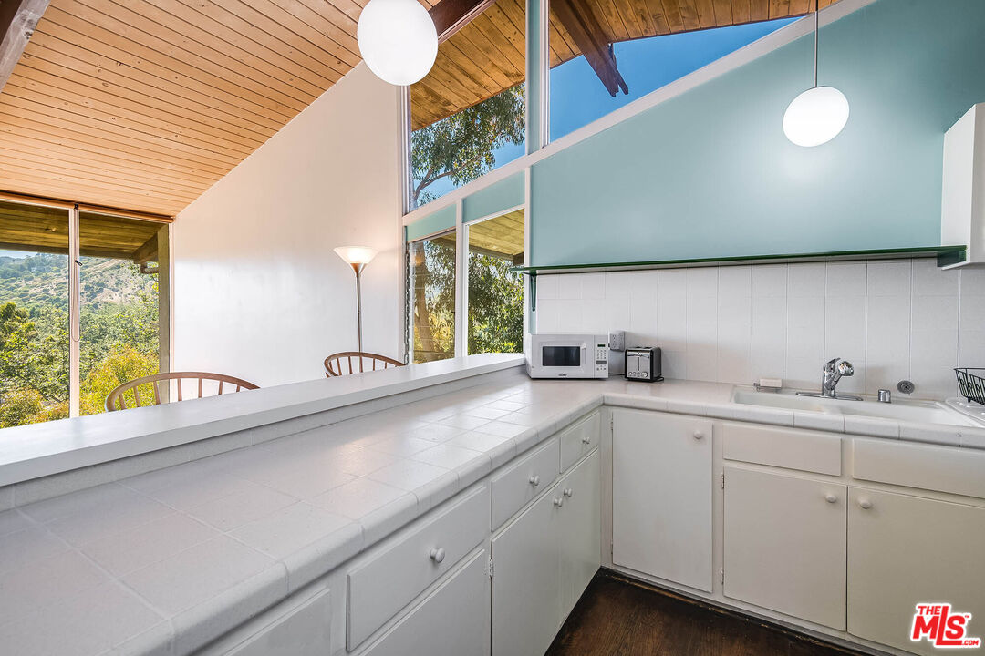 3557 Serra Road Malibu, CA 90265 - Photo 14 of 32 a kitchen with sink attached with living room