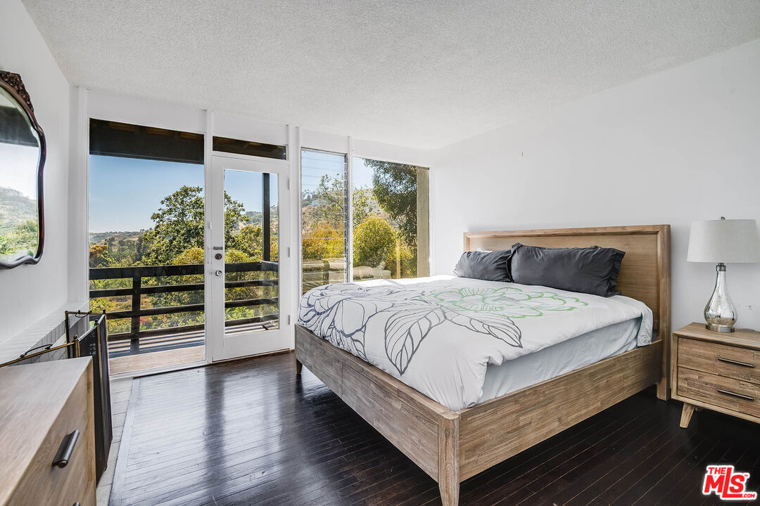 3557 Serra Road Malibu, CA 90265 - Photo 21 of 32 a bed sitting in a bedroom next to a window
