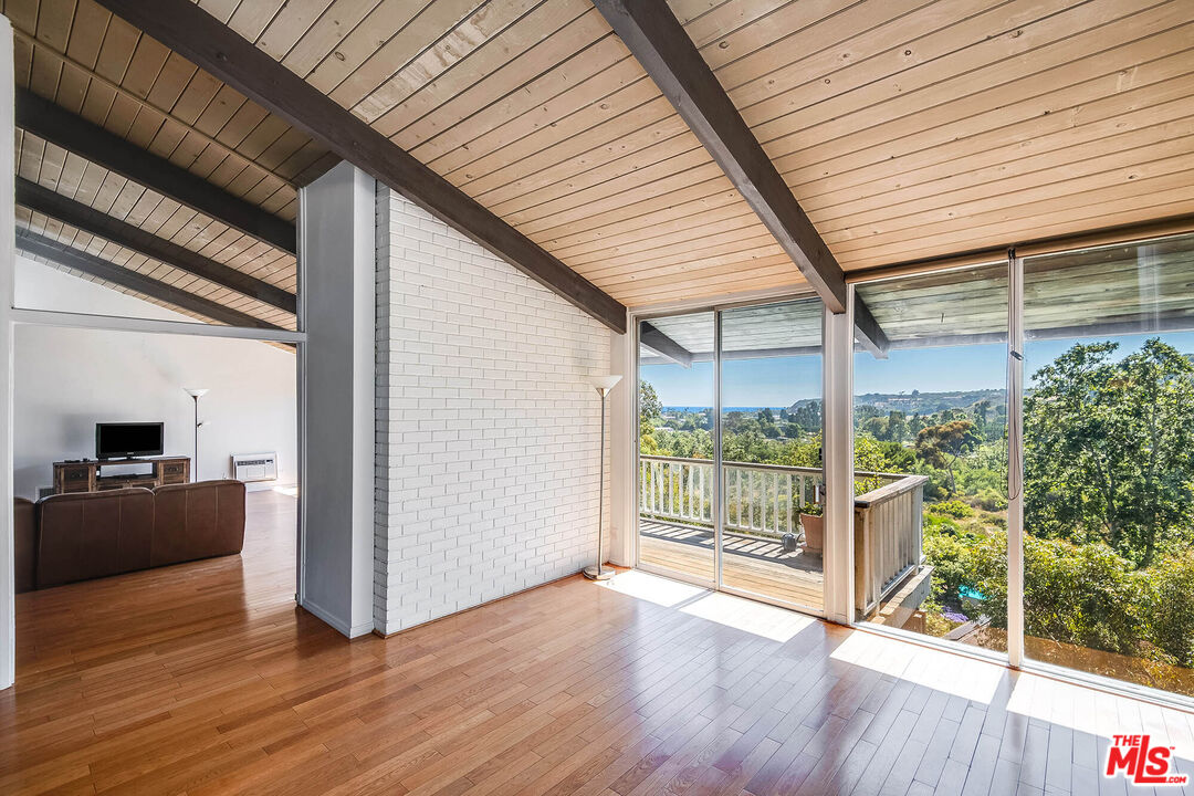 3557 Serra Road Malibu, CA 90265 - Photo 5 of 32 a view of a porch with wooden floor and floor to ceiling window