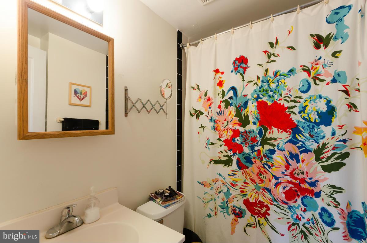 2008 16th Street Northwest, Unit 302 Washington, DC 20009 - Photo 8 of 11 a bathroom with a sink and mirror with painted walls