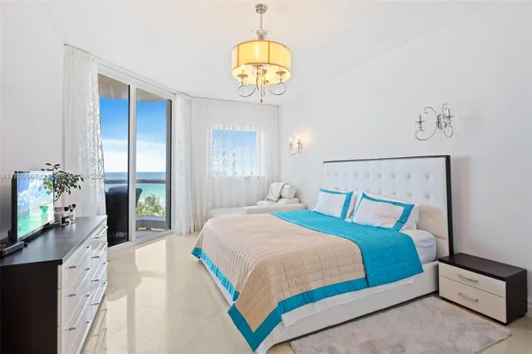 a bedroom with a bed and a chandelier