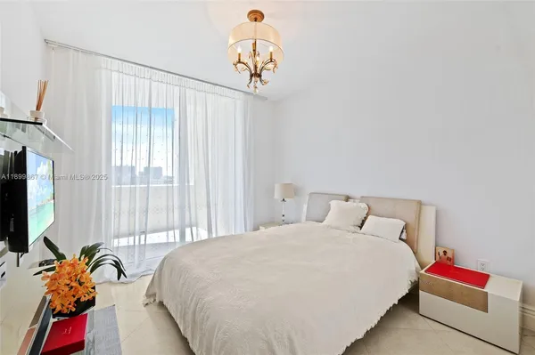 a bedroom with a bed and a chandelier