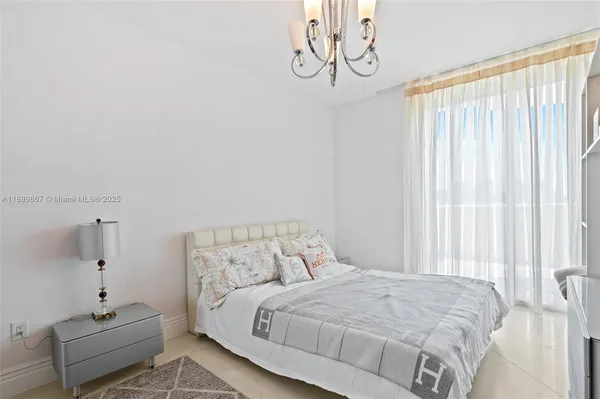 a bedroom with a bed and a chandelier